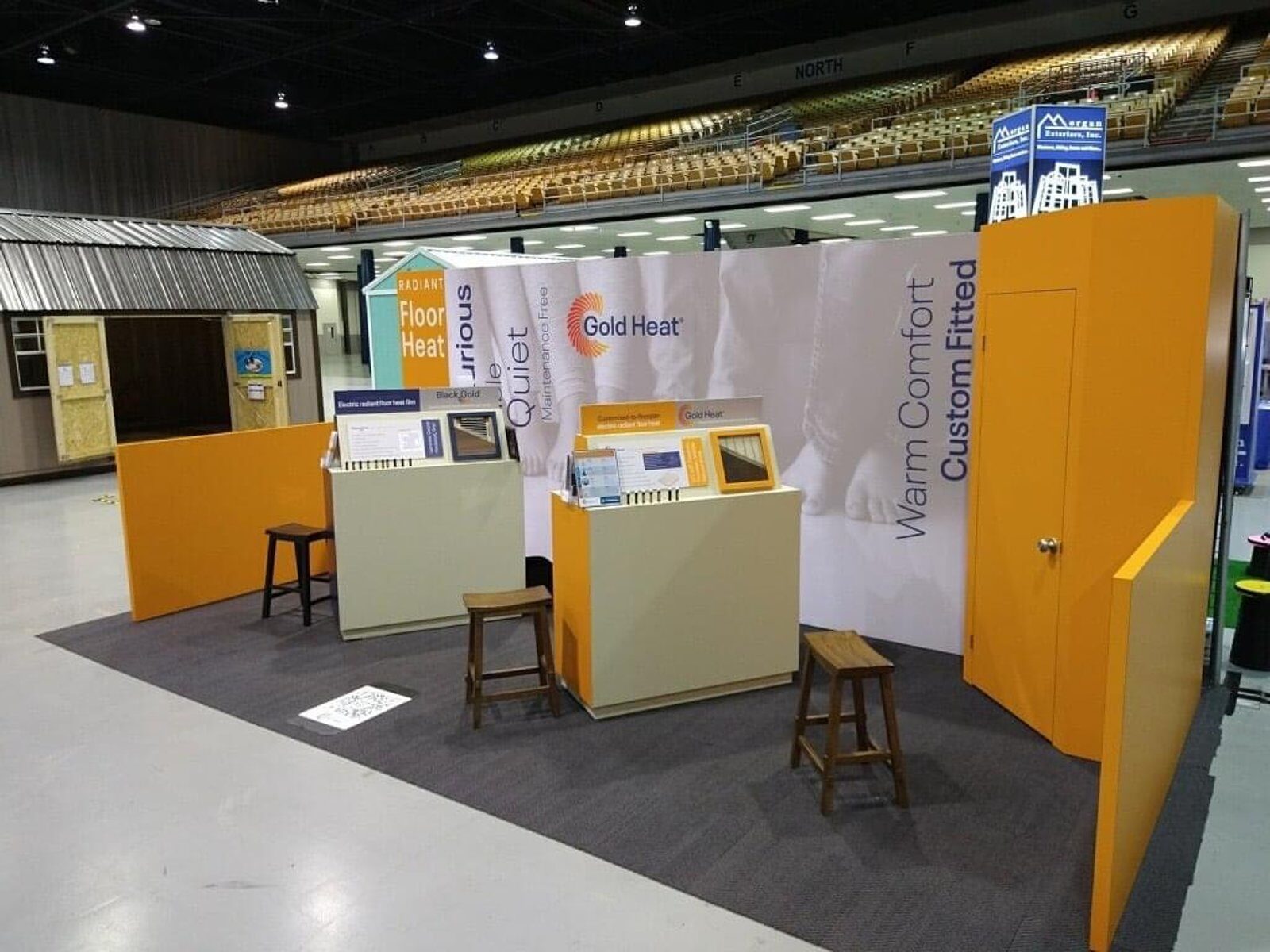 Compact inline booth with a printed fabric backwall and a demonstration structure